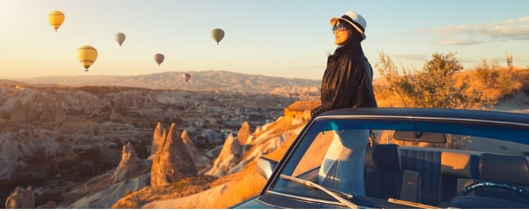 Allianz - woman watching colorful hot air balloons flying over the valley at Cappadocia