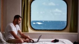 man using laptop on cruise ship