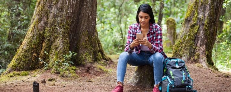 Allianz - woman with smartphone in forest