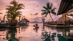 man swimming at luxurious resort