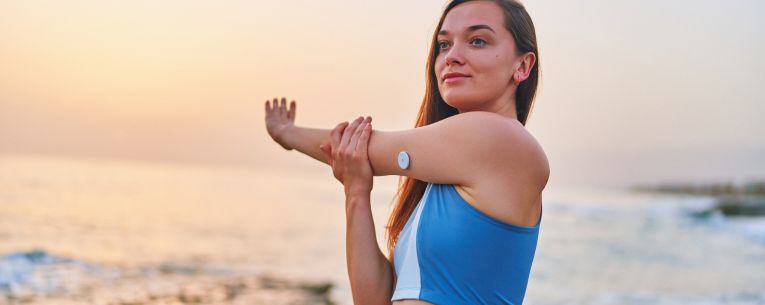 Allianz - woman stretching with glucose monitor