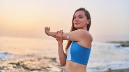 woman stretching with glucose monitor