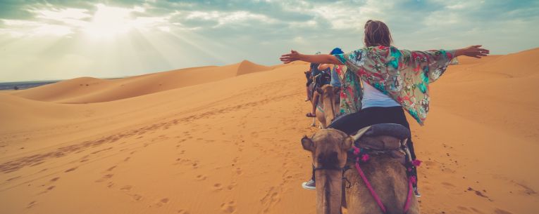 Allianz - travelers on camelback in the desert